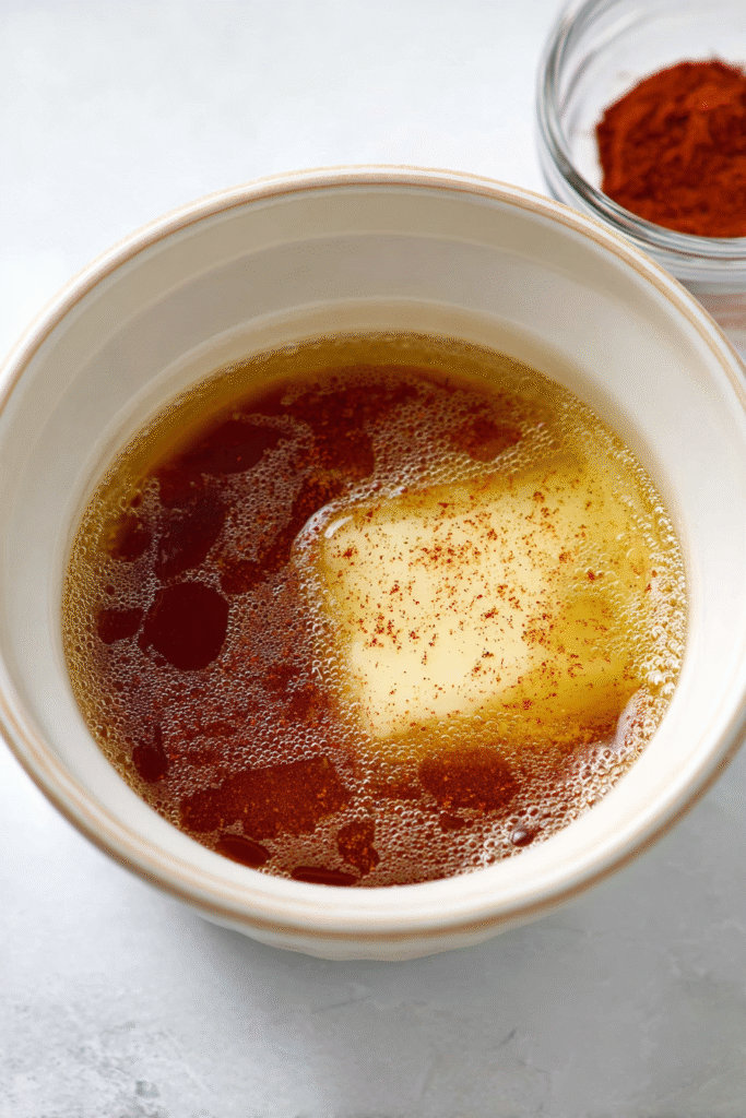 melting butter and honey in saucepan for hot honey popcorn with spices on the side
