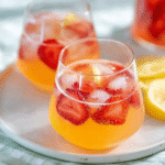 Strawberry mango lemonade in a clear glass with fresh fruit
