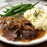 French Onion Pot Roast in Dutch oven with caramelized onions and gravy